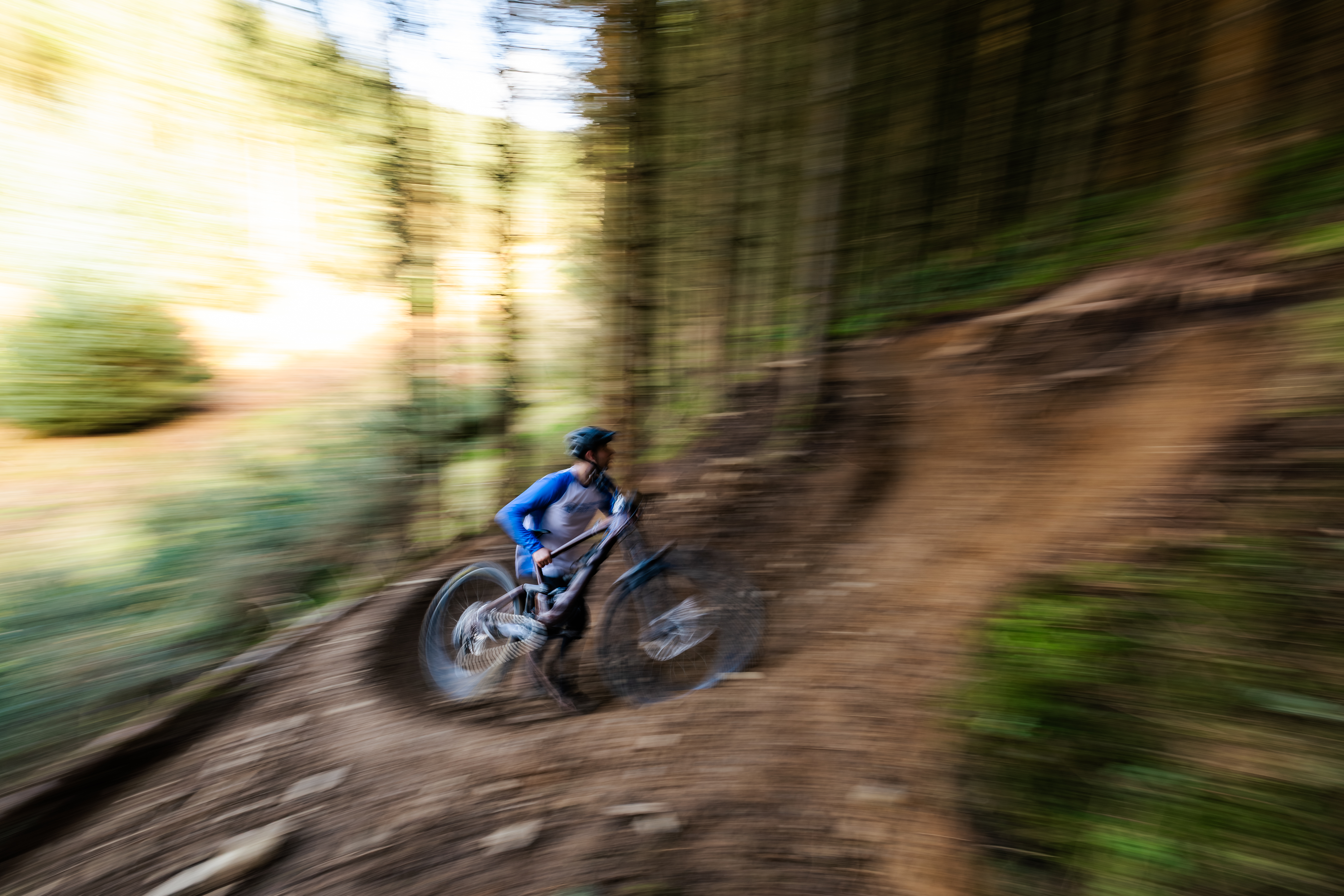 Fuzzy image of a person on their bike in the forest 