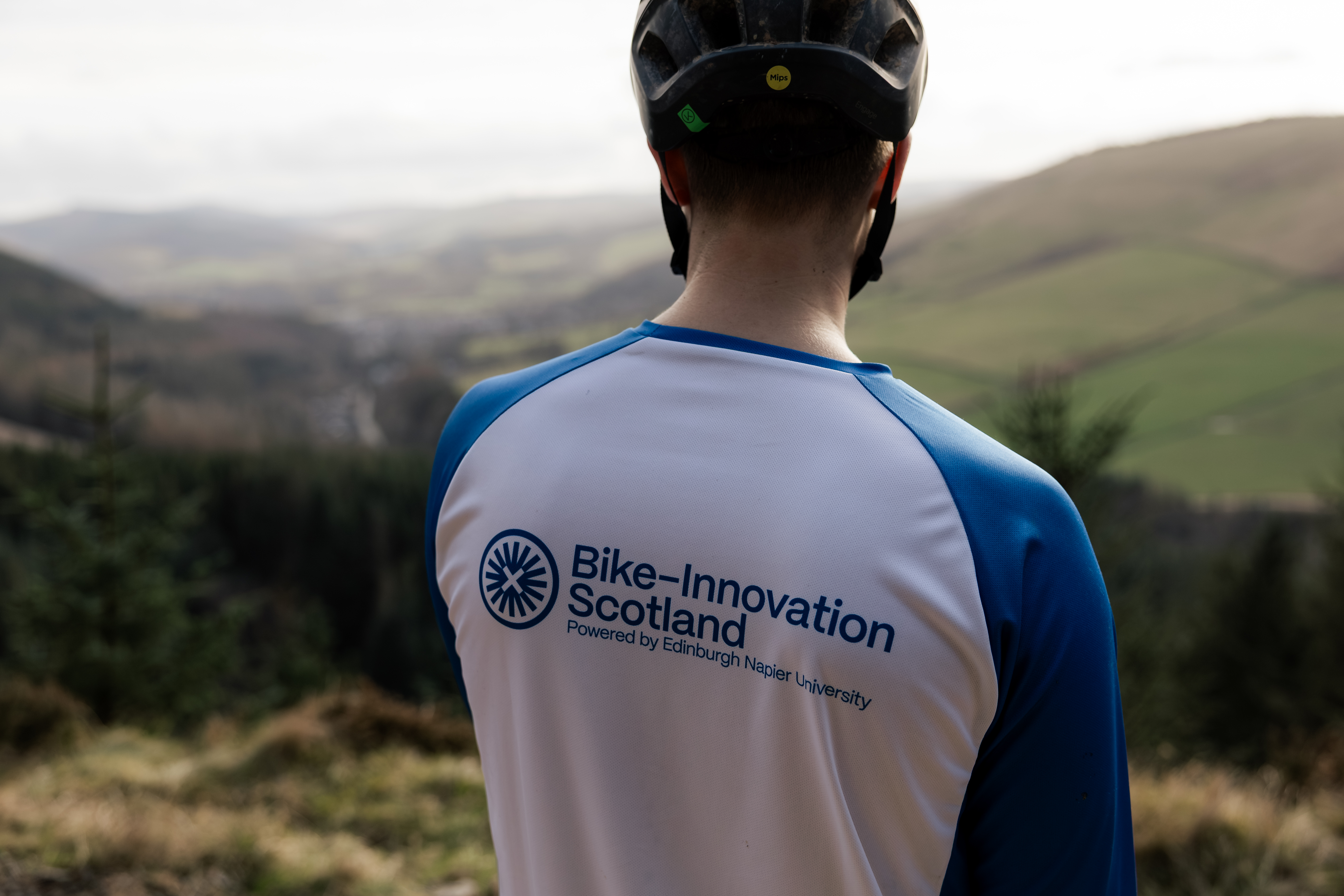 Back of a person wearing a t-shirt with Bike Innovation Scotland logo on it 