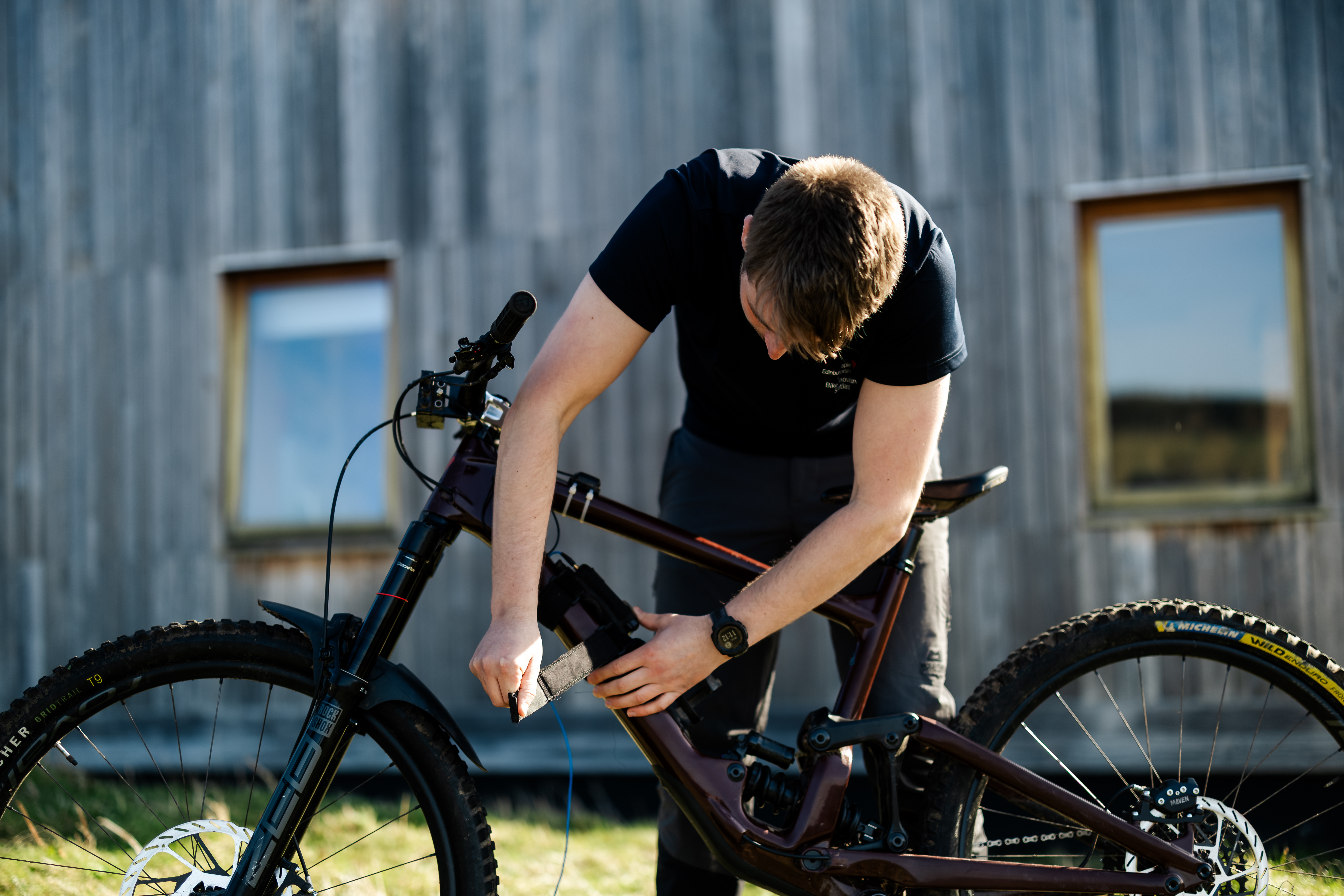 Person attaching something to their bike frame